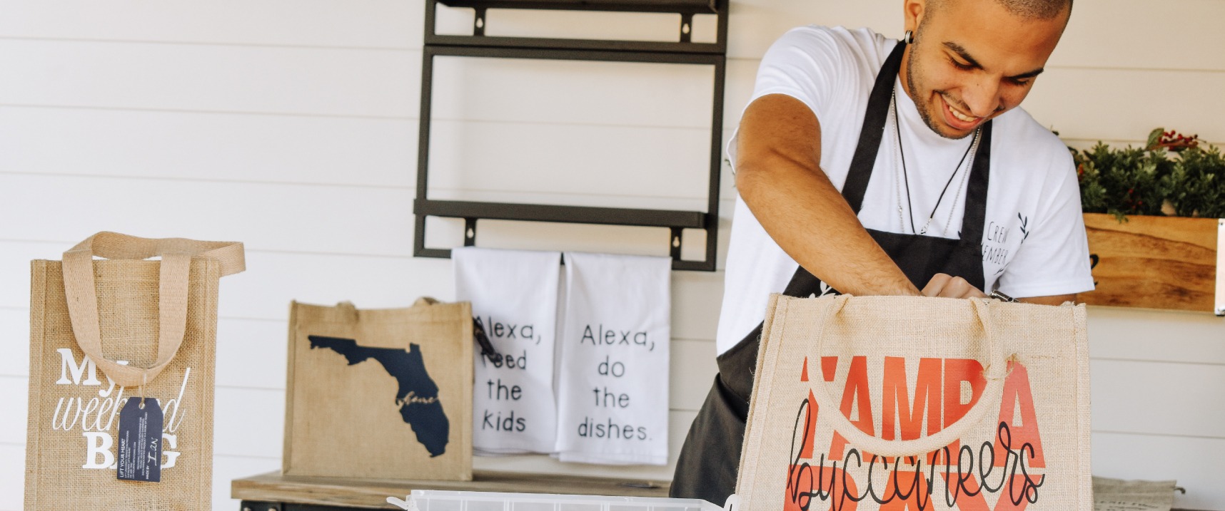 One LiFT Your Heart team member packing canvas bag with red letters Tampa Bay, script Buccaneers.